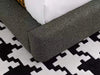 Miller Bed Frame with curved upholstered base on patterned rug.