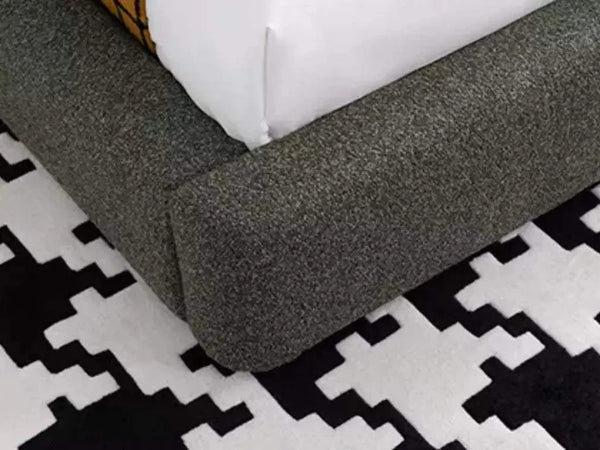 Miller Bed Frame with curved upholstered base on patterned rug.