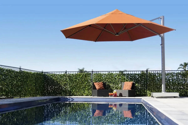 Serenity Rotating Cantilever Outdoor Umbrella with orange Sunbrella canopy beside pool