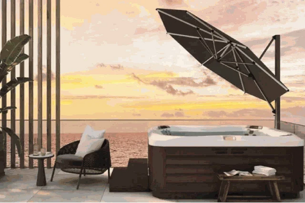 SU4 Tilting Offset Outdoor Umbrella providing adjustable shade next to a hot tub on a patio at sunset