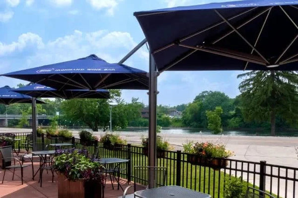 Unity Multi-Canopy Cantilever Outdoor Umbrella providing shaded outdoor seating with navy blue Sunbrella fabric canopies and durable marine-grade aluminum frame.