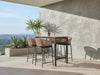 Como Outdoor Wicker Bar Chair with charcoal aluminium frame and natte sooty fabric in outdoor setting
