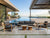 Mirage outdoor sofa setting with teak frames and charcoal cushions beside a contemporary pool