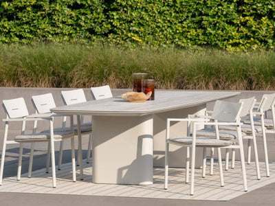 Amorelli Outdoor Ceramic Dining Table in garden setting with chairs, featuring a sleek ceramic top and durable aluminum base, perfect for outdoor gatherings.