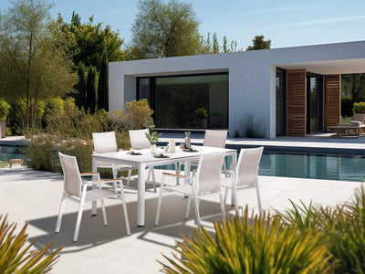 Outdoor dining area with Aspen Outdoor Arm Dining Chairs around a table by a pool.