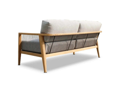 Tribu Outdoor Lounge 2 seater outdoor sofa with teak frame, handwoven rope details, and light grey Sunbrella cushions.