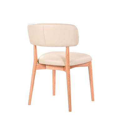 Ayla Dining Chair with polished oak frame and light mocha leather seat showcasing soft curves and modern elegance.