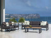 modern 2 seater outdoor sofa with gray cushions, teak arm trims, and aluminum frame on patio overlooking sea
