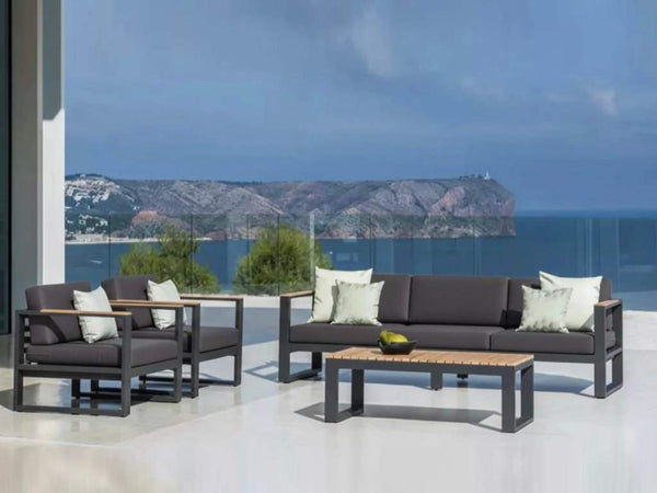 modern 2 seater outdoor sofa with gray cushions, teak arm trims, and aluminum frame on patio overlooking sea