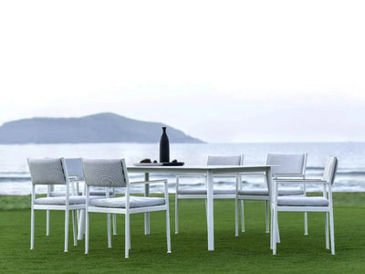 Bonigen Outdoor Dining Chair set on a coastal lawn with ocean view.