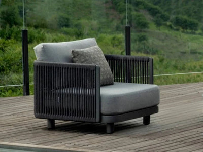 Bonito Outdoor Lounge 1-Seater Sofa on deck with greenery background, charcoal frame, and cushion.
