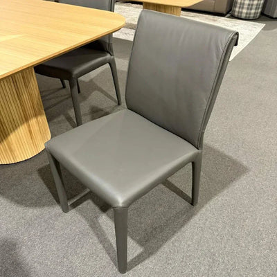 Modern fully upholstered leather dining chair in iron leather with sleek padded seat and backrest.