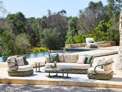 Canasta green outdoor sofa set with lounge chairs beside a pool