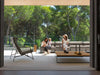 Casilda Outdoor Corner Lounge with neutral cushions and wooden accents on a modern patio with people and a dog outdoors