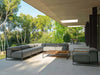 Modern Casilda Outdoor Corner Lounge with neutral cushions and wooden accents on a covered patio surrounded by greenery
