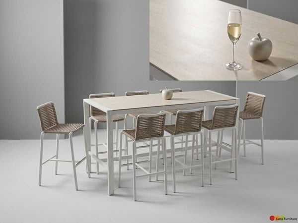 Cebu Outdoor Ceramic Bar Table with white aluminium frame and light cement ceramic top, paired with woven rattan bar stools.