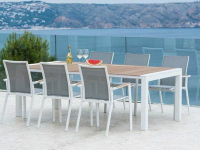 Cebu Outdoor Teak Dining Table with white frame, set for dining on outdoor terrace with ocean view.