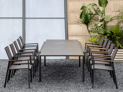 Cebu Outdoor Ceramic Extendable Dining Table with aluminum base and sleek ceramic top, surrounded by chairs in an outdoor setting.