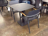 Coco Outdoor Dining Chair with aluminium frame and teak armrest trims in a modern outdoor setting.