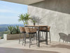Como Outdoor Wicker Bar Chair with charcoal aluminium frame and natte sooty fabric in outdoor setting