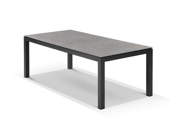 Dante Outdoor Ceramic Dining Table with charcoal frame and marble ceramic top in stylish outdoor setting