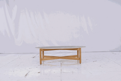Dewata Outdoor Low Coffee Table with oval stone tabletop and wooden base, ideal for patios and gardens.