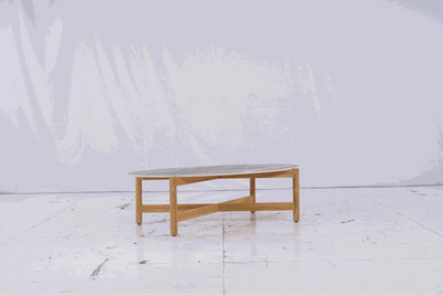 Dewata Outdoor Low Coffee Table with wooden base and oval stone tabletop.