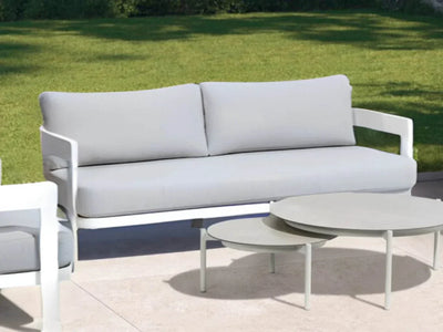 Domani Outdoor Lounge - 2.5 Seater Sofa with white aluminum frame and Natte Grey Chine fabric, placed outdoors.