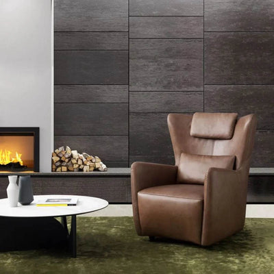 Embrace Leather Armchair in modern living room setting with fireplace.