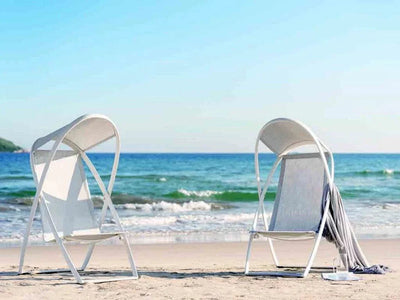 Halo Outdoor Lounge Chair by the beach with sleek aluminum frame and all-weather sling.