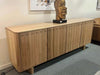 Elegant Jordan Buffet with carved door fronts and soft edges in a living room setting.