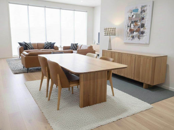 Jordan Dining Table with solid pillar base and curved edges in modern dining room setting