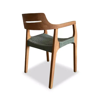 Outdoor teak dining chair with curved arms, woven sage green seat, and contoured backrest.