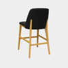 Kai Leather Bar Chair with black leather seat, curved backrest, and natural oak legs.