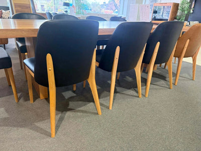 Kai Leather Dining Chair with solid timber legs in a dining room setting.