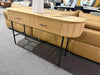 Lantone Hall Table in natural oak, featuring two drawers with black handles, ribbed corners, and sleek metal legs, in a contemporary living space.
