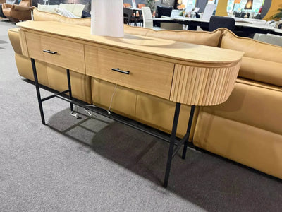 Lantone Hall Table in natural oak, featuring two drawers with black handles, ribbed corners, and sleek metal legs, in a contemporary living space.