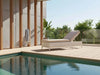 Malibu Sun Lounger in natural kubu wicker with grey cushion by poolside on wooden deck