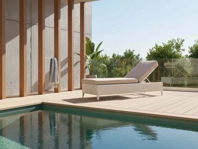 Malibu Sun Lounger in natural kubu wicker with grey cushion by poolside on wooden deck