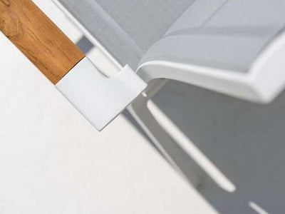 Teak trim detail on the Marbella Outdoor Sling Dining Chair armrest.