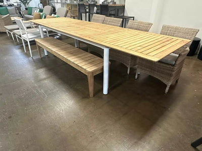 Milan Outdoor Teak Extendable Dining Table set with premium A-grade teak tabletop and stainless steel frame in indoor showroom.