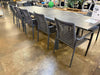 Milan Outdoor Rope Chair with woven design and aluminum frame in charcoal color, set around a large outdoor dining table.