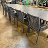 Milan Outdoor Rope Chair with woven texture and aluminum frame around a table in an outdoor setting.