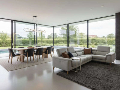 Modern dining room featuring an Australian Made Solid Timber Dining Table with black chairs and large windows overlooking a garden and pool.