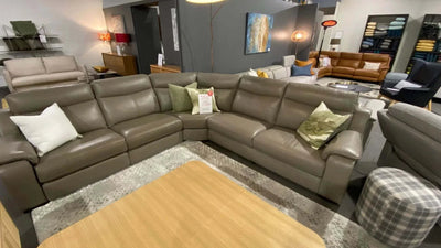 Morgan corner sofa in gray leather with electric recliner, cushions, and clearance sale price displayed in a furniture showroom setting