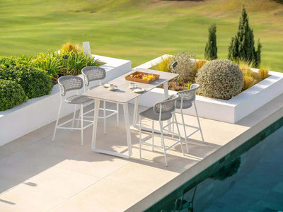 Butterfly Outdoor Bar Chair by pool with aluminum frame and woven design.