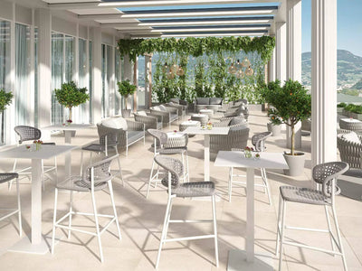 Butterfly Outdoor Bar Chair in elegant patio setting with woven Italian polyethylene rope and durable aluminum frame.