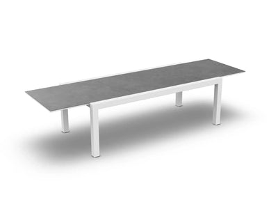 Extendable Livorno Outdoor Ceramic Dining Table with white frame and grey cement top.