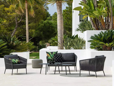 Jiselle Outdoor Lounge - 2.5 Seater Rope Sofa on patio amidst lush greenery.