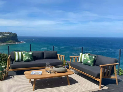 Finley Outdoor Lounge - 1 Seater Sofa on patio overlooking ocean, teak frame with dark cushions.